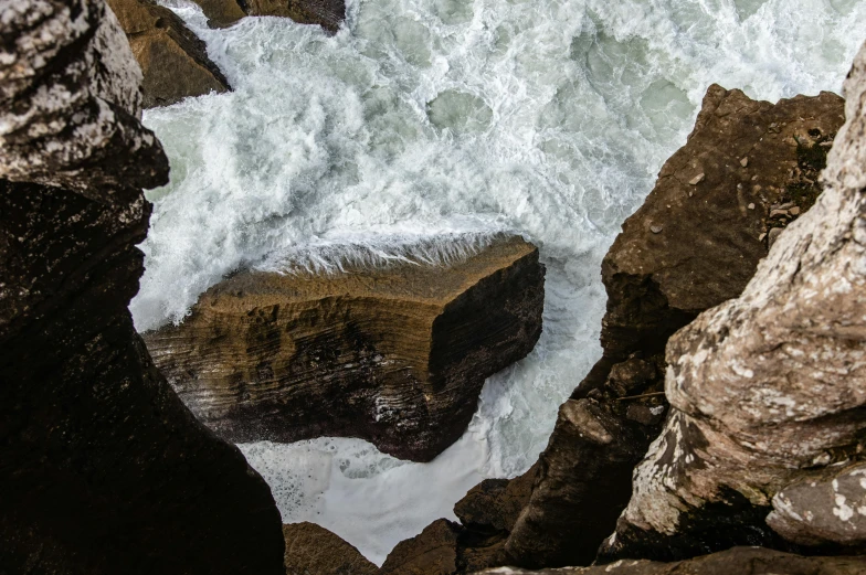 a close s of some water with rocky formations and grass