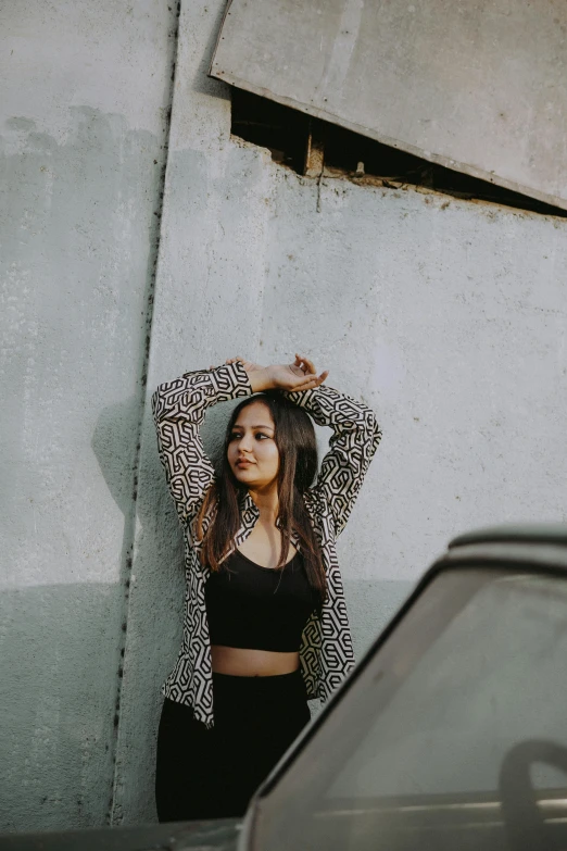 a woman is standing by a wall, looking at soing