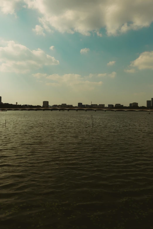 a large body of water with tall buildings and sky in the background