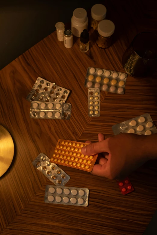 a person reaching for pills from another box