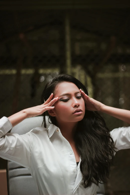 a woman is holding her hair up to her face