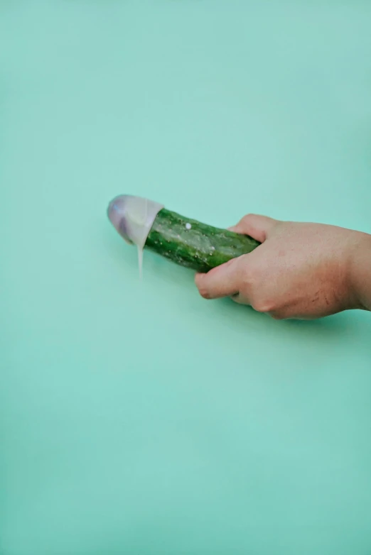 a cucumber is being squeezed by someone who's holding it