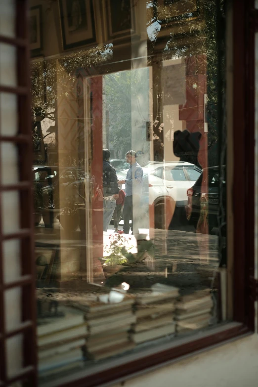 window with reflection of man standing in liry