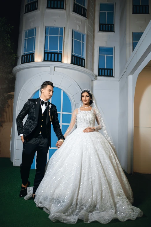 a couple poses for their wedding portrait in front of a house