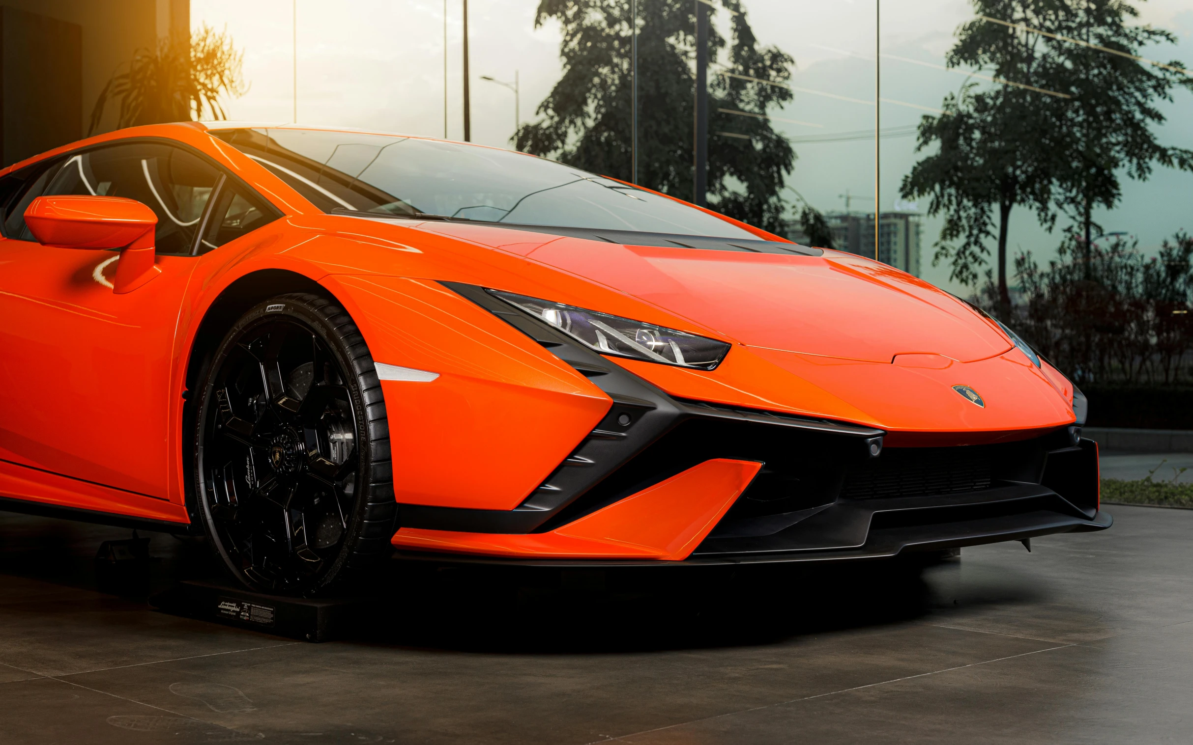 an orange sports car parked in front of a building