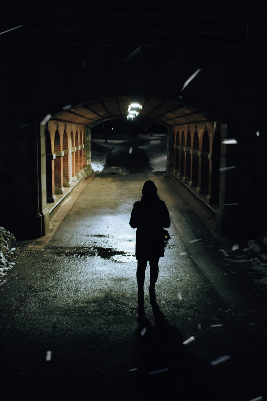 someone walking down the street towards a tunnel