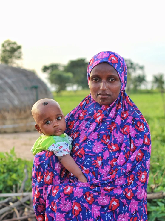 a woman holding a baby in her arms and looking down