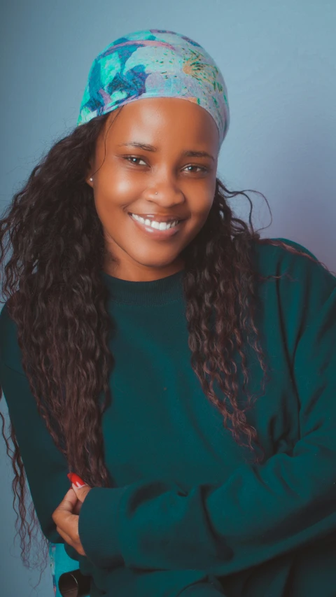 a person standing with her arms crossed wearing a headband