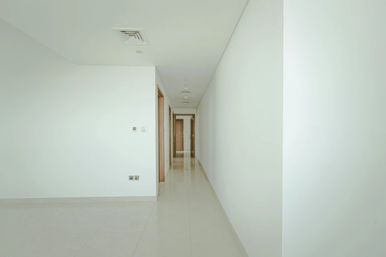 the hallway has a tile floor, large doors, and light