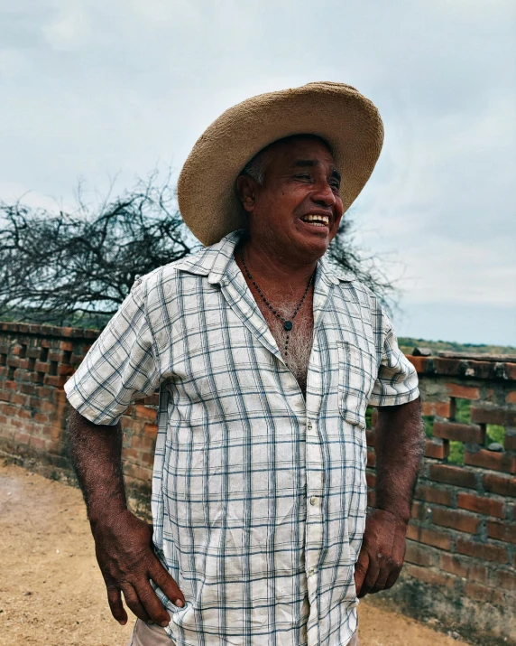 a man in a plaid shirt and hat looking at soing