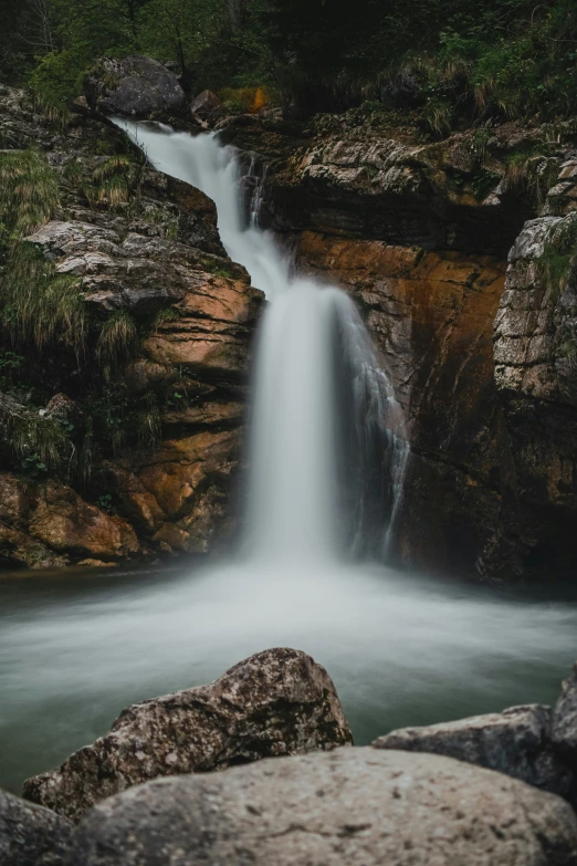 a small waterfall cascading down into the middle of a forest