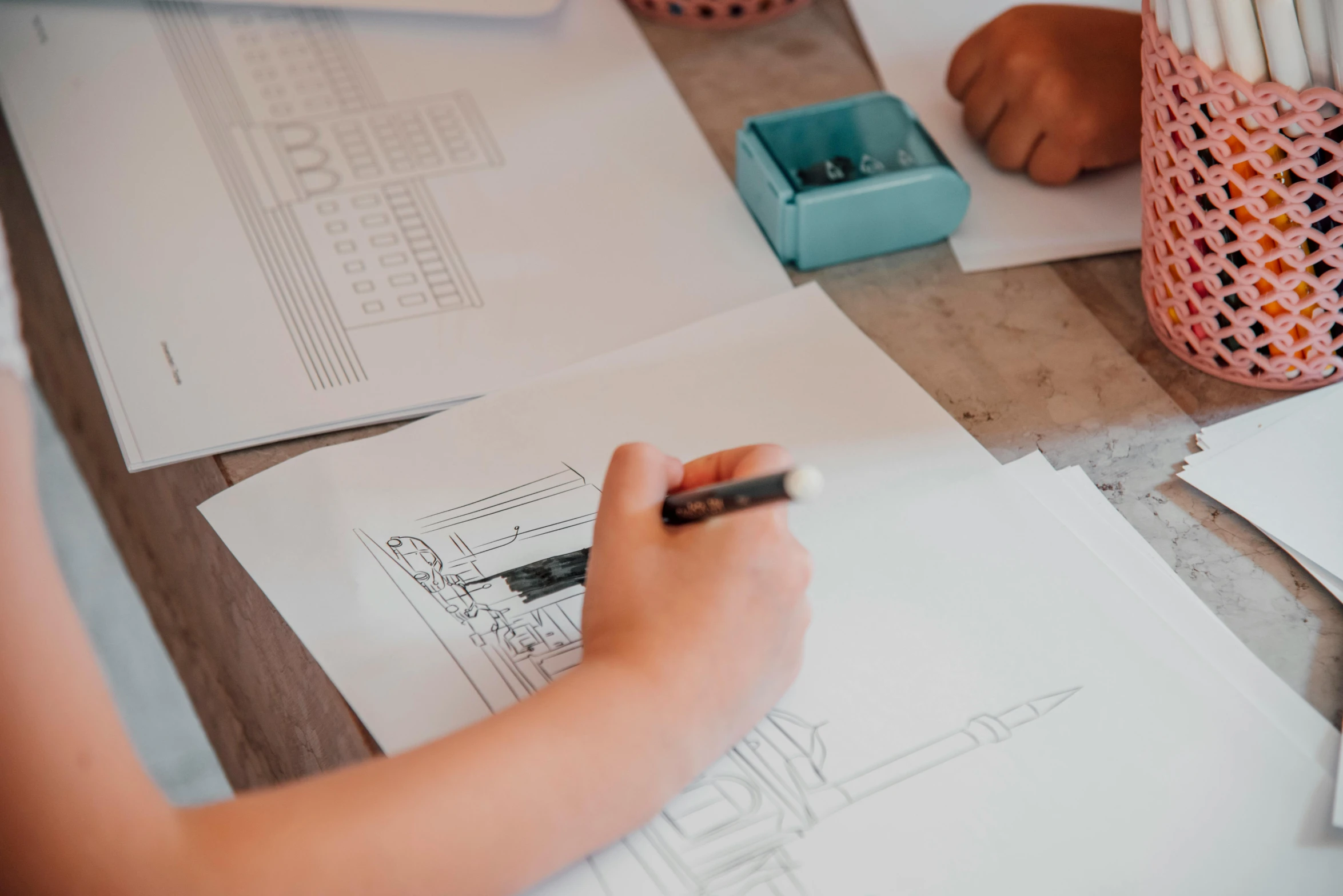 a person working with architectural drawings on a desk