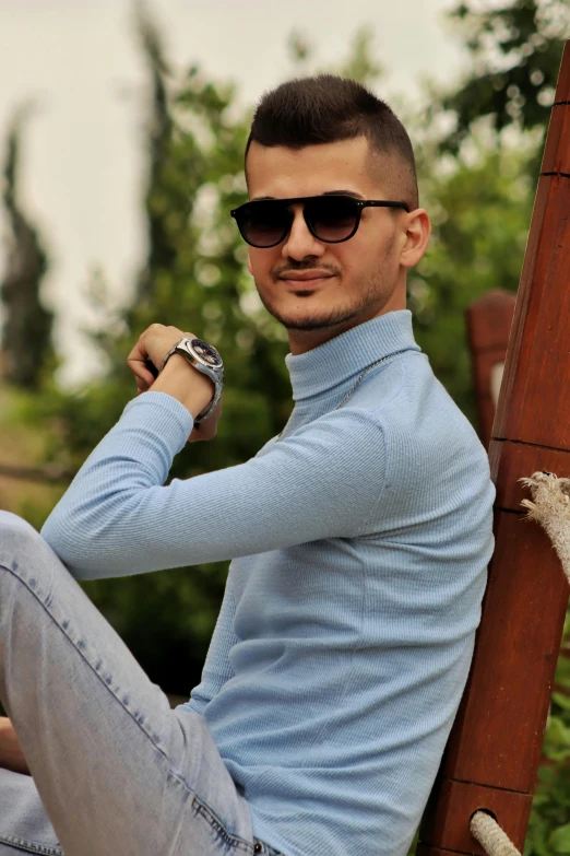 a man wearing sunglasses posing in the park