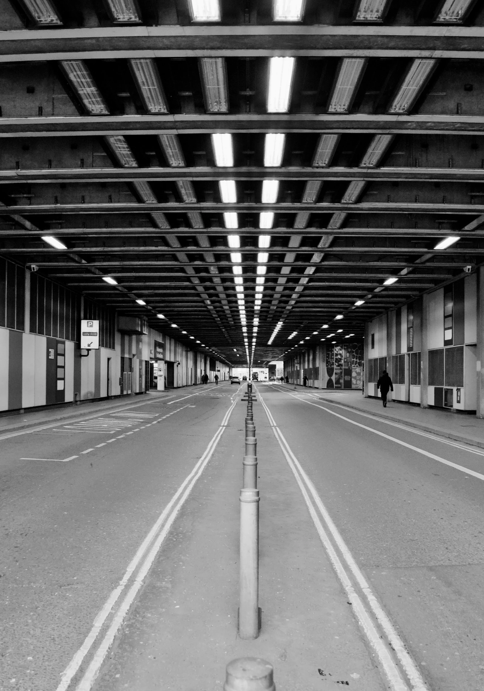 a long empty empty parking garage next to a fire hydrant