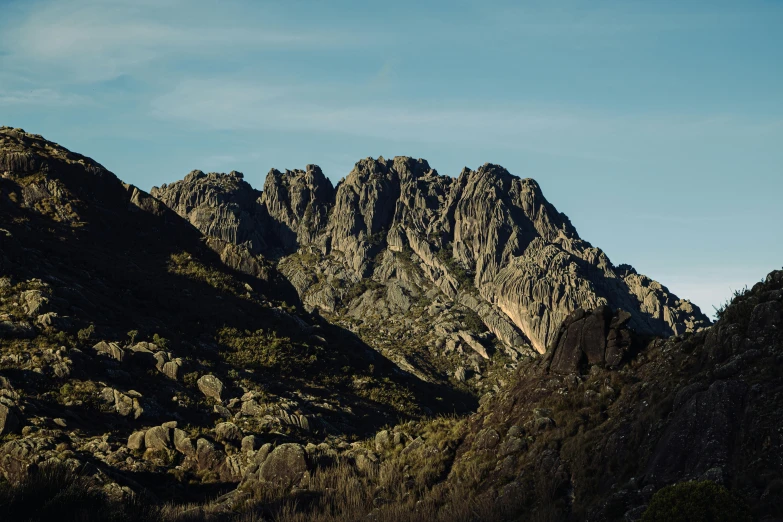 a picture of mountains taken from below a blue sky