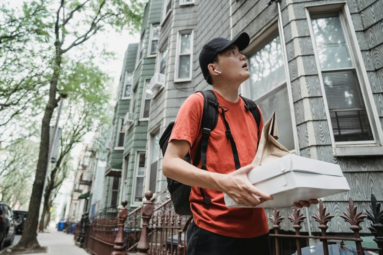 a man carrying a pizza box in a city