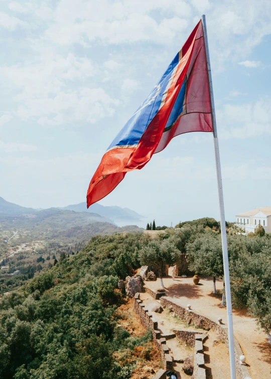 there is a large flag flying on top of the mountain