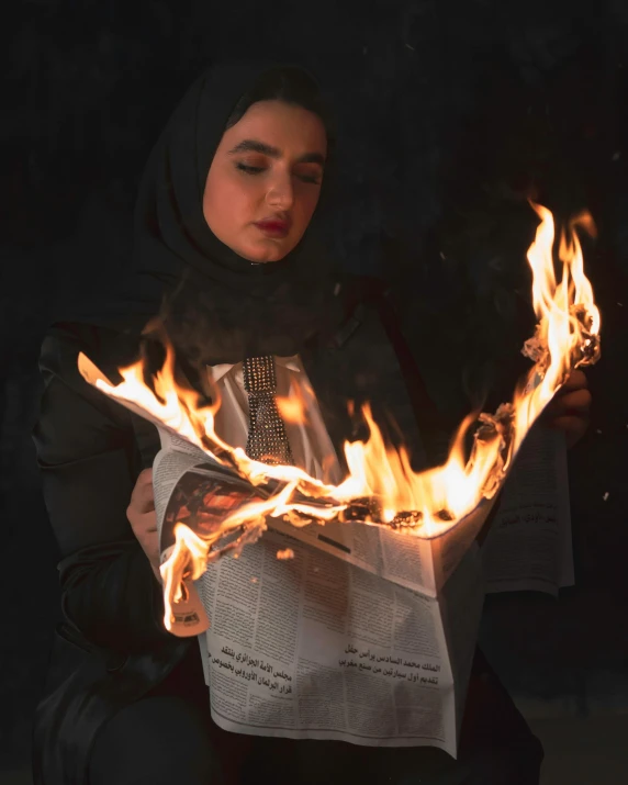 a woman reading a newspaper surrounded by fire