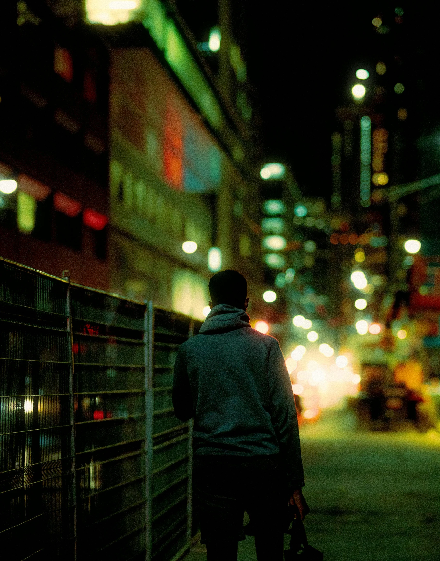 the back of a person walking in the city at night
