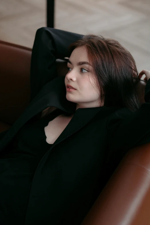 a beautiful young lady sitting down wearing black