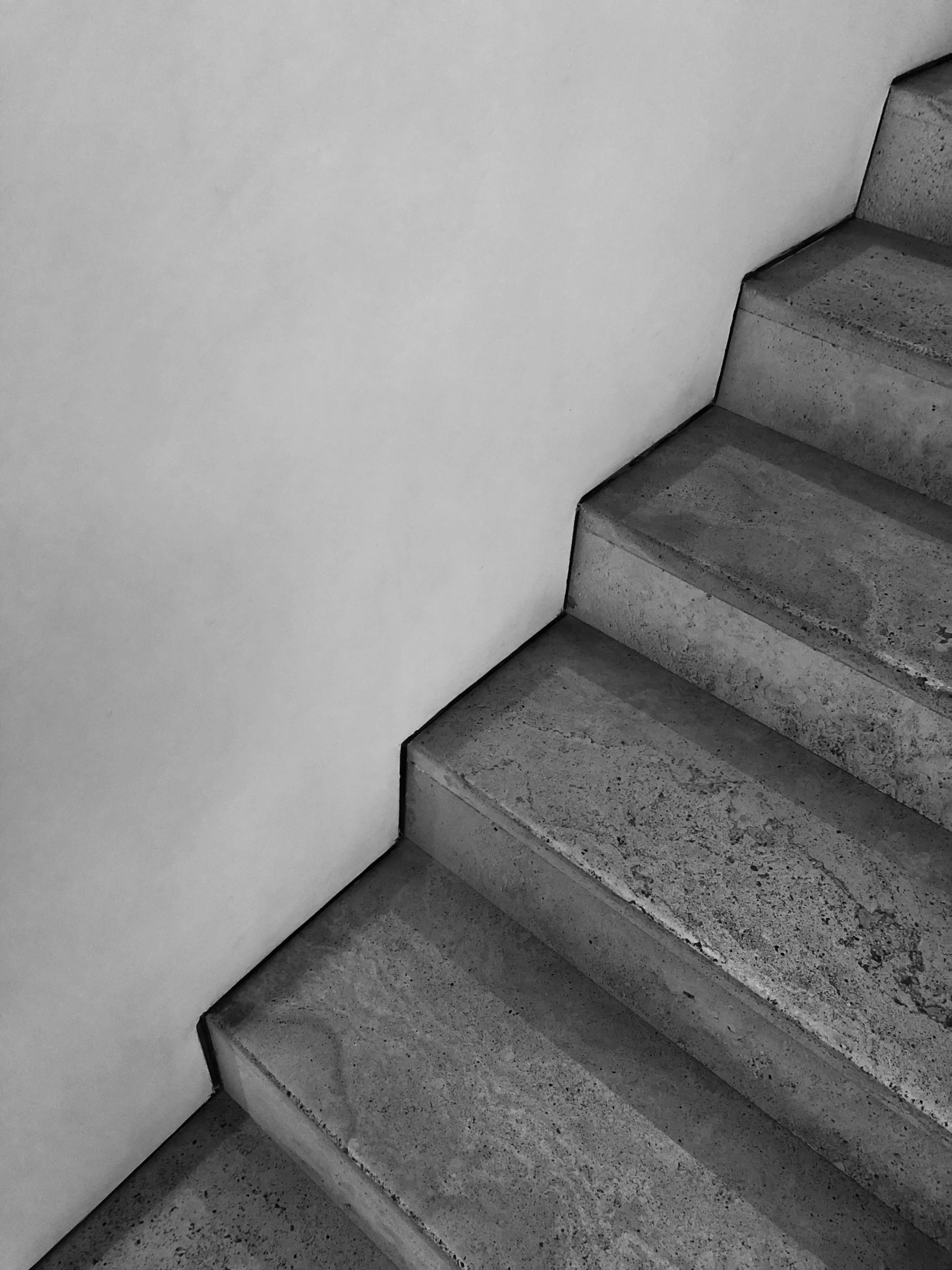 an empty stair is seen on a white wall