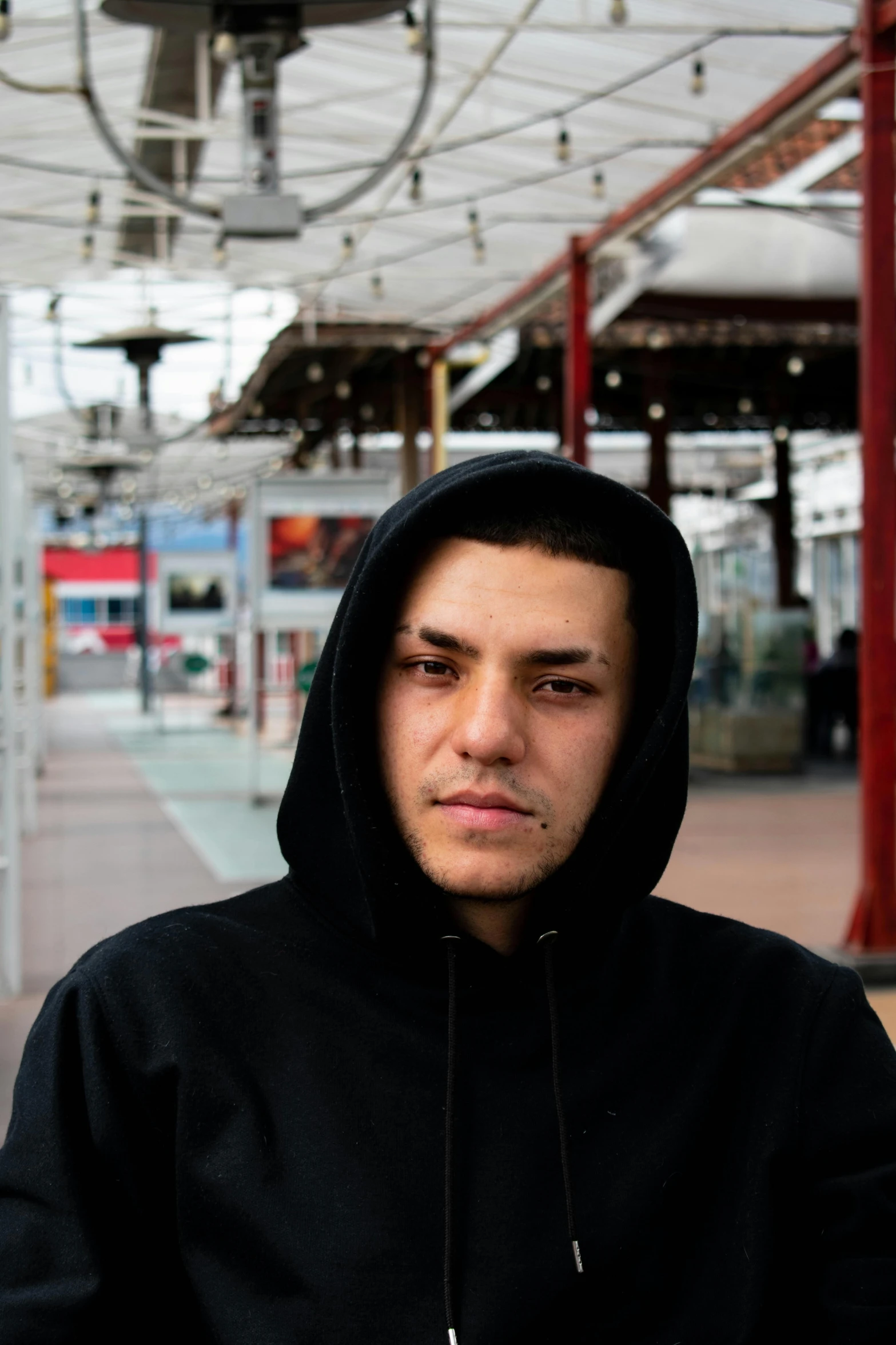 a young man in black wearing a black hoodie