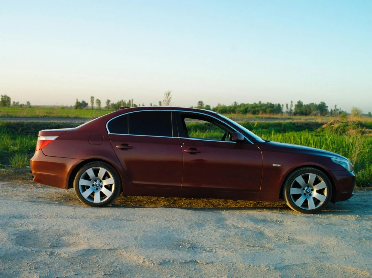 a dark red car parked on the side of a road