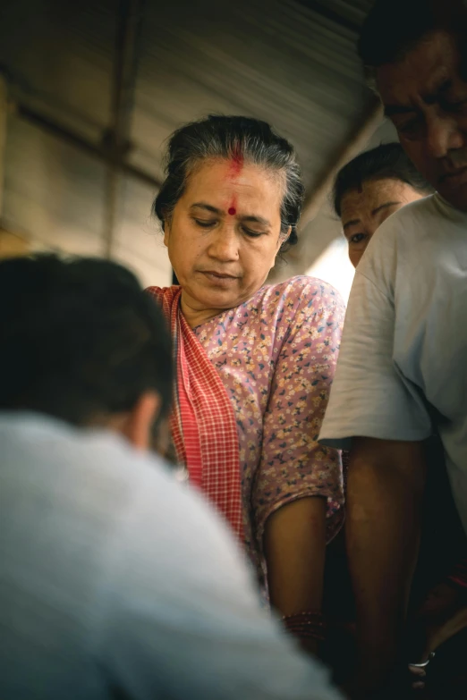 a woman is looking at soing while others look on