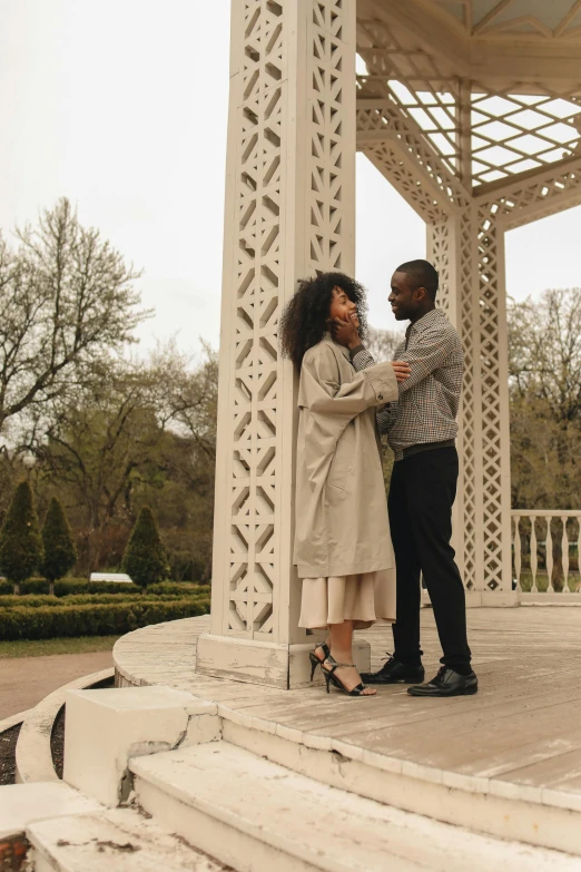 a man and woman are standing together under a gazebo