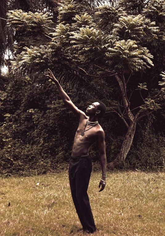 a shirtless man in a field holding a frisbee