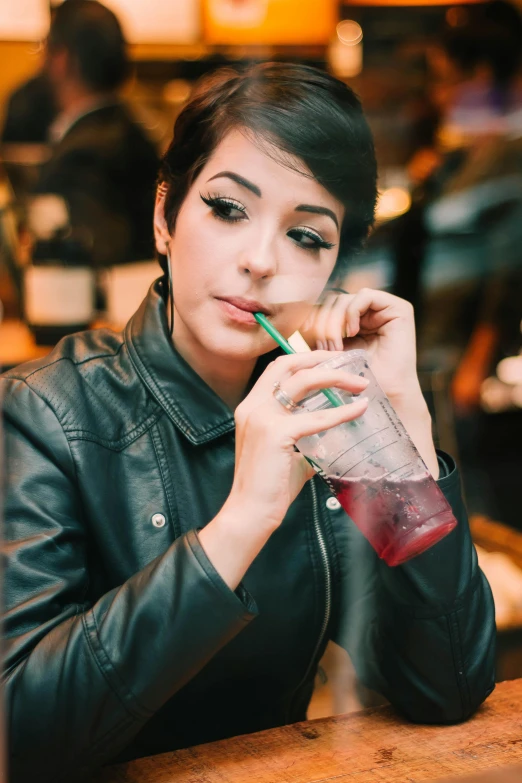 a woman is drinking from a smoothie cup