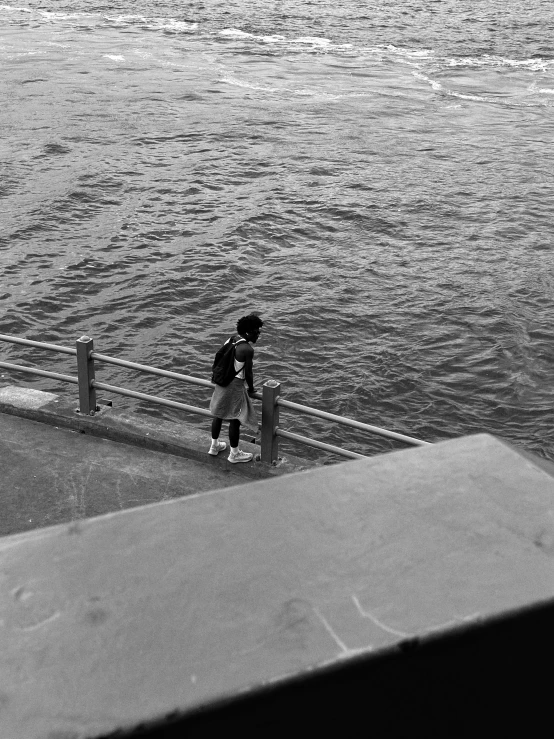 a  wearing a helmet is standing next to the water