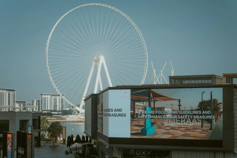 a giant wheel on a city street with tall buildings