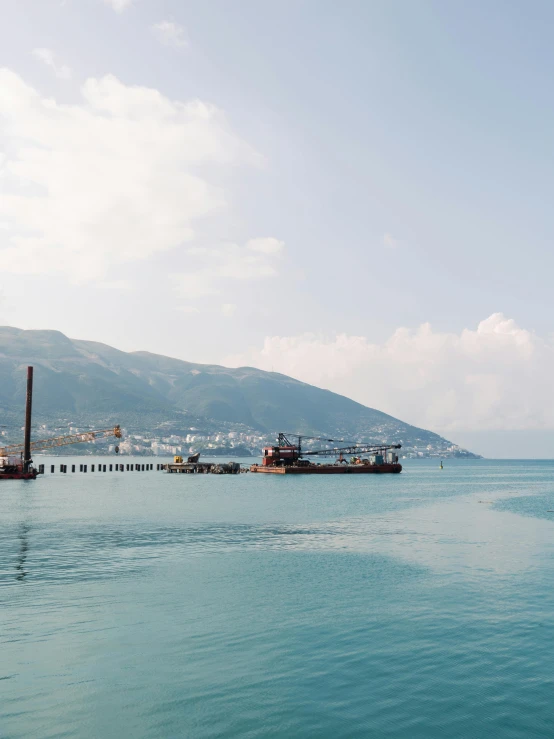 the large boats are traveling past the mountain range