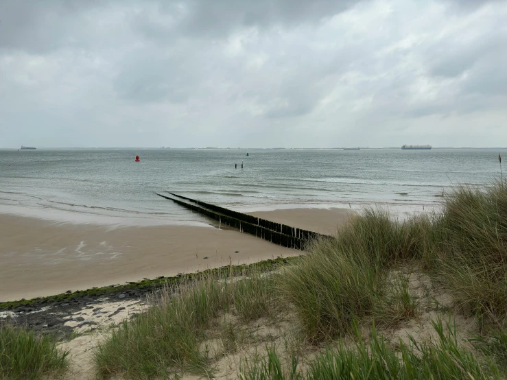 a wooden break in the sand near the ocean