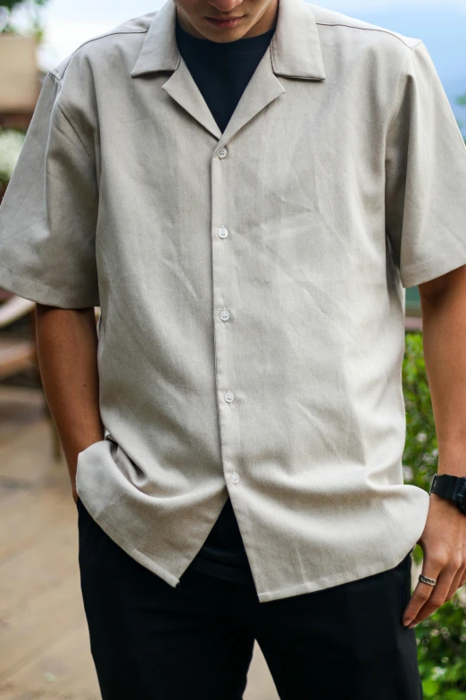 a man wearing an unoned shirt looks away