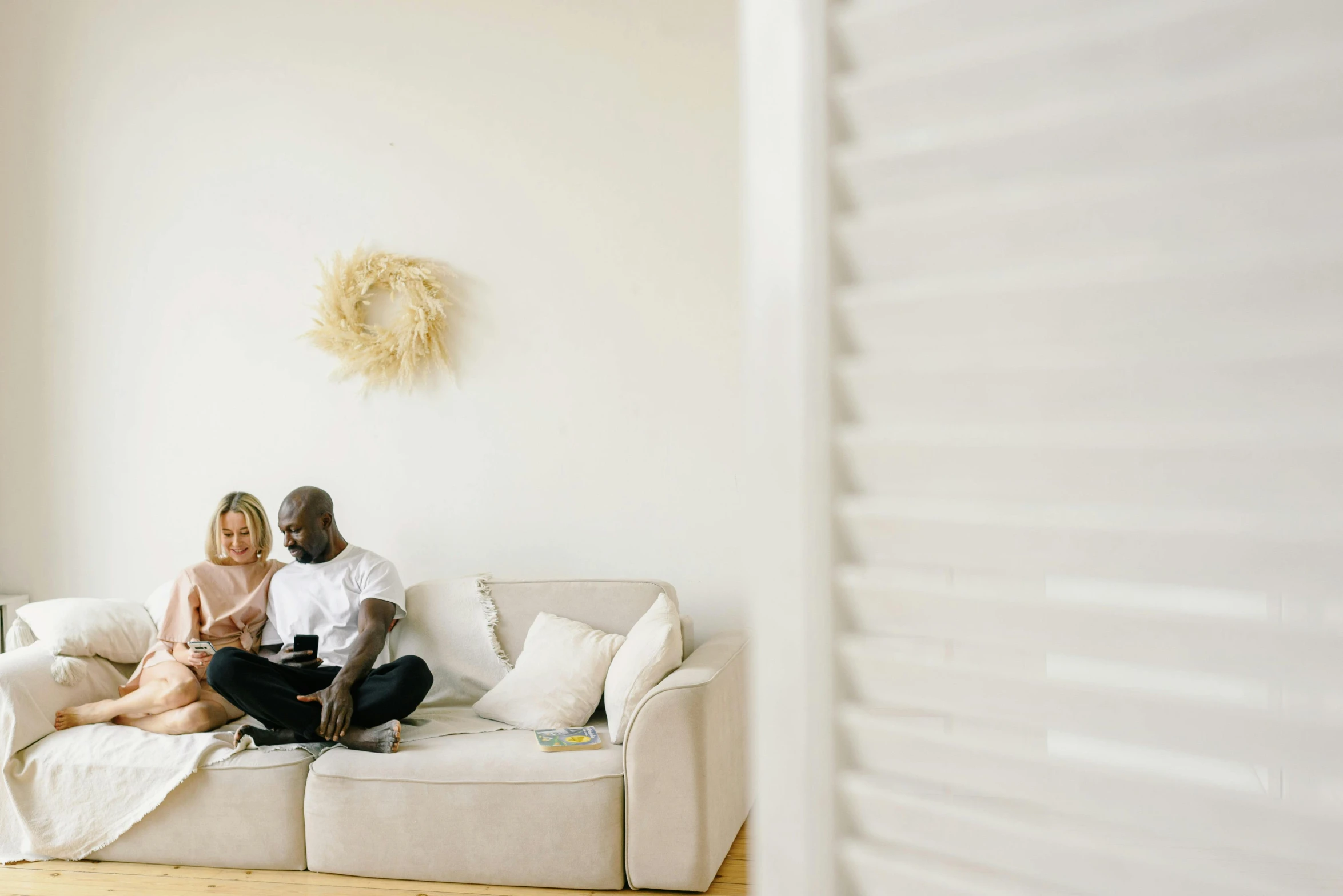 two people are sitting on a couch, and one person is holding a remote