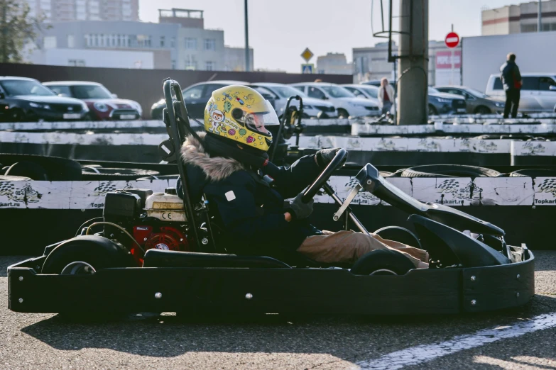 a small child riding on a go kart while wearing a helmet