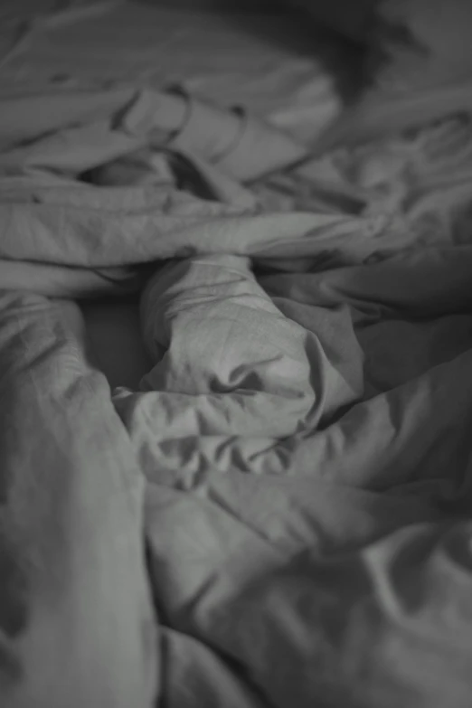 a person laying in bed with one hand on his chest and one holding a pillow under the covers