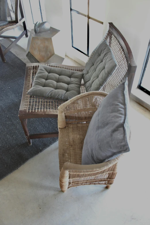 wicker chairs and footstools are in the center of a room