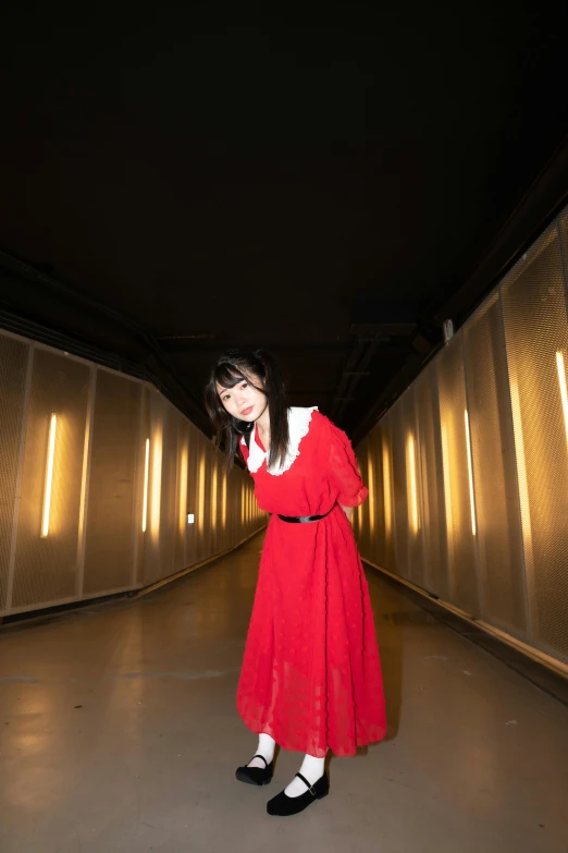 girl in a long red dress standing alone with hand on hips