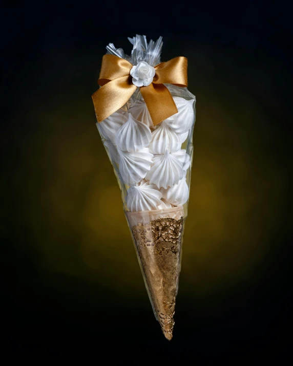 an ice cream cone wrapped in gold foil with ribbon