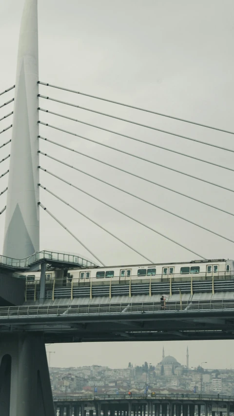 a commuter train moving across a bridge with cables