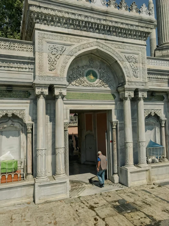 an ornate doorway leads into a building with a clock tower in the background