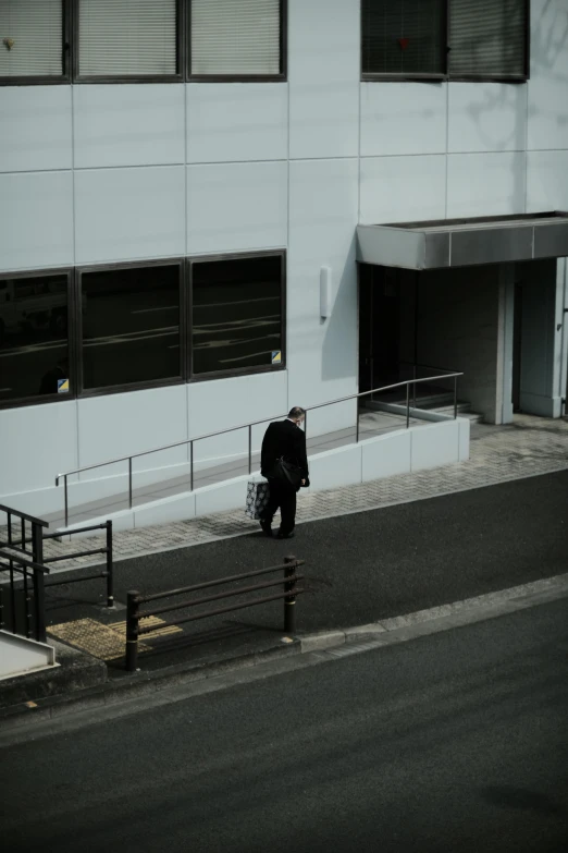 a person with luggage walks by a building