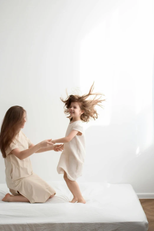 two women dancing on a mattress next to each other