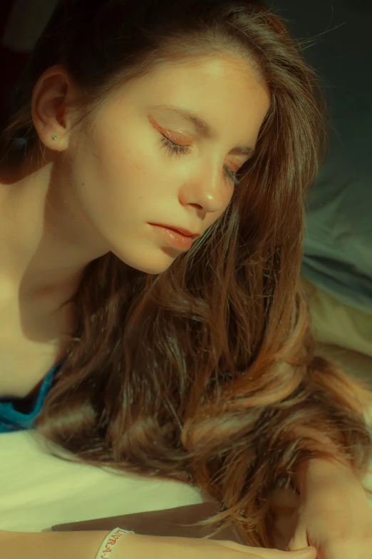 a girl with her eyes closed laying on top of a bed