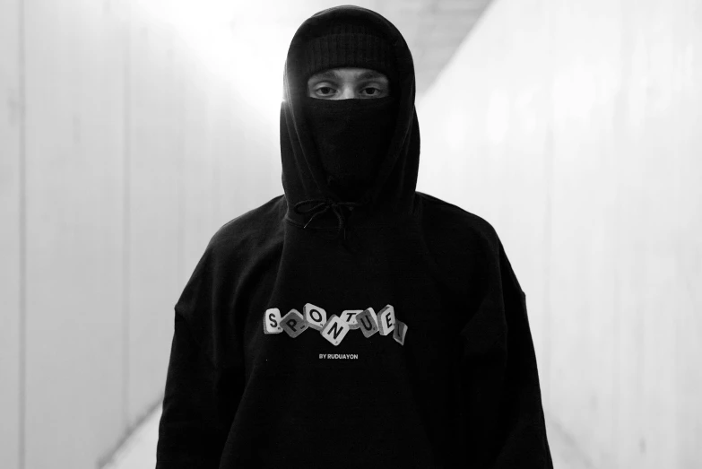 man in black hoodie standing in a hallway