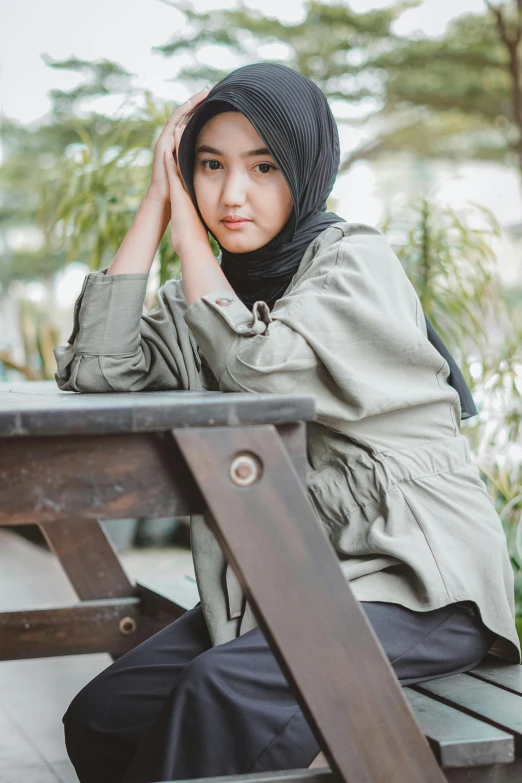 a woman sitting at a table and posing