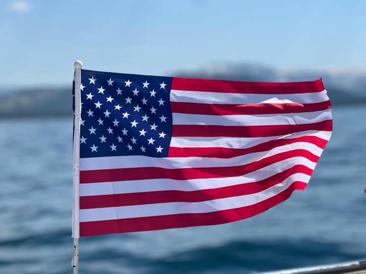 an american flag flying over water on a boat